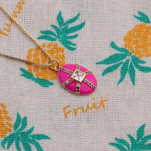 Vue macro du pendentif ovale en émail rose avec pierres multicolores et zircon central