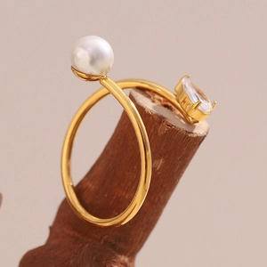 Detail of 18K gold-plated snake ring with round pearl and teardrop zircon on wood