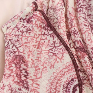 Detail of red paisley print fabric with high-precision overlock edge stitching quality
