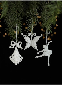 Close-up of white glitter Christmas ornaments with butterfly and ballet dancer shapes