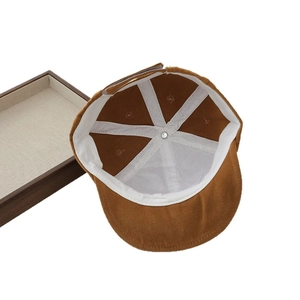 Inside view of brown cotton baby cap showing the six-panel interior and white lining