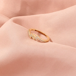 Close-up of golden paperclip ring with micro-pave zircons on soft pink silk fabric