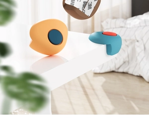 Detail showing colorful L-shaped silicone corner guards with 3M adhesive on white table