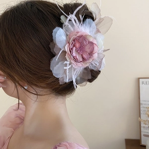 Détail de la pince à fleurs avec pétales en soie et plumes blanches délicates élégantes