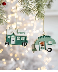 Close-up of green camper and house Christmas ornaments hanging on a festive pine tree