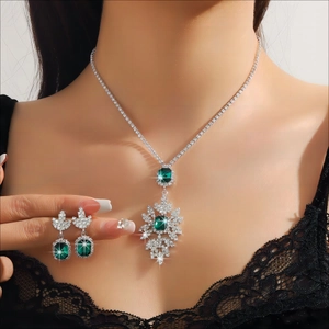 Close-up of model wearing emerald green crystal fringe necklace and earrings set