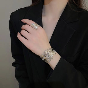 Dettaglio del set bracciale e anello a fiore in argento con trame di petali rifinite
