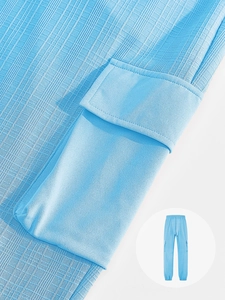 Detail view of light blue cargo pants showing textured breathable fabric and pocket flap