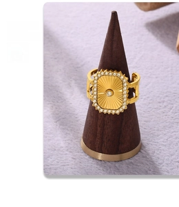 Détail d'une bague dorée style Grande Roue avec zircons sur présentoir en bois