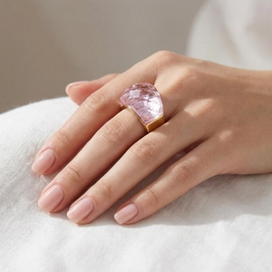Close-up of a pink faceted crystal stone on a 18K gold plated wide band ring