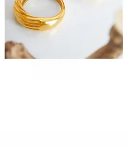 Close-up of gold-plated thick ring with unique twisted rope texture and polished mirror finish