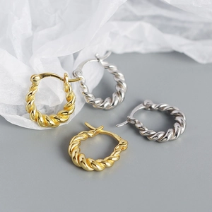 Detailed view of twisted rope texture U-shape hoop earrings in gold and silver finishes