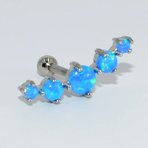 Vue macro d'un piercing courbe avec cinq opales bleues serties sur acier inoxydable
