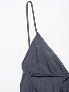 Detailed view of the fine textile texture and pleated V-neckline of a dark grey dress