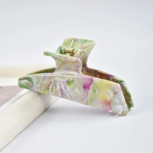 Detailed close-up of marble pattern hair claw clip with colorful resin swirls and metal spring