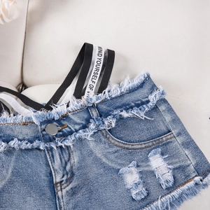 Dettaglio degli shorts in denim azzurro con bordi sfilacciati e vita elastica