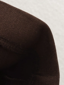 Macro shot of dark brown ribbed knit fabric texture on cuff and hem of the suit
