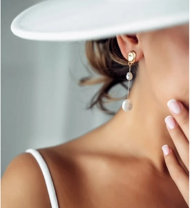 Close-up of geometric S925 silver needle drop earrings with white baroque pearls