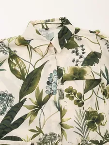 Detailed close-up of light beige floral shirt with green leaf patterns and collar details
