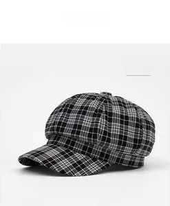 Close-up of a black and white checkered octagonal newsboy cap on a white background