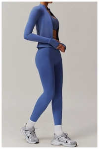 Detail view of misty blue athletic set showing zipper jacket thumbholes and high waist leggings
