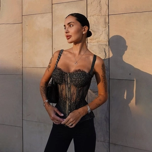 Detail of black lace corset top featuring floral patterns and supportive boning structure