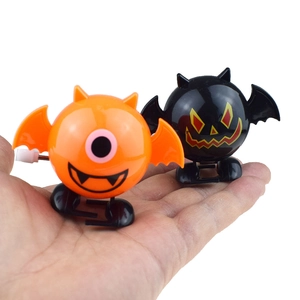 Halloween clockwork jumping toys with orange monster and black bat designs in hand