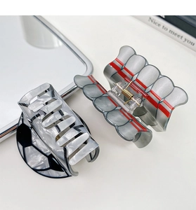 Macro detail of high-quality marble texture and red stripe sports style hair claw clips