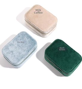 Three velvet jewelry organizers in blue, green, and beige with zippers on white background