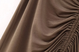 Detailed close-up of dark brown ruched fabric with premium elastic knitted texture