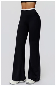 Détail du pantalon de yoga évasé à taille haute avec ceinture contrastée blanche sur noir