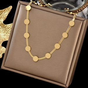 Détail du collier chaîne serpent dorée avec de petits disques ronds sur présentoir