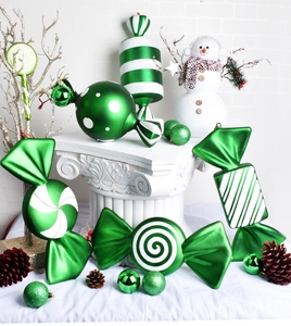 Macro view of green candy Christmas ornaments with glitter stripes and dots texture