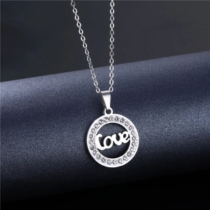 Macro shot of silver-tone hollow circle necklace with love text and clear rhinestones