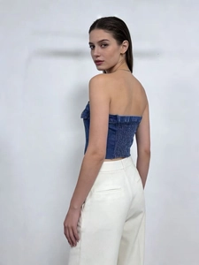 Dettaglio top a fascia in denim blu con arricciatura elastica posteriore e taglio slim