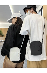 Detailed comparison of black and white crossbody bags showing nylon texture and adjustable straps