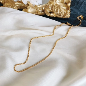 Elegant 18K gold-plated stainless steel twist rope chain necklace on white silk background