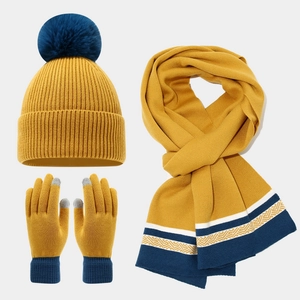 Three-piece winter knit set with pompom hat, scarf, and touch-screen gloves in mustard yellow