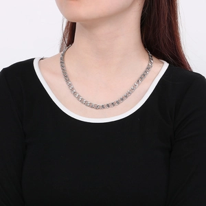 Detail shot of a silver-toned paperclip chain necklace shown worn on a female model