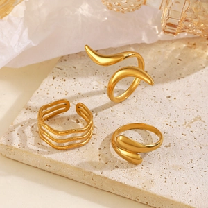 Three 18K gold plated stainless steel irregular rings set on a stone display board