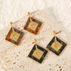 Macro detail of resin hoop earrings with tortoiseshell and black marble patterns