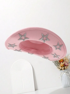 Pink felt cowboy hat with silver sequin stars on the brim displayed with white decor