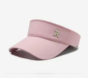Detail of light pink sun visor hat with R letter embroidery in high-quality sports fabric
