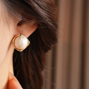 Close-up of a model wearing a French vintage gold round pearl stud earring