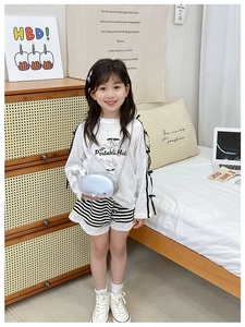 Detail of cute silver whale crossbody bag paired with kids striped long sleeve t-shirt