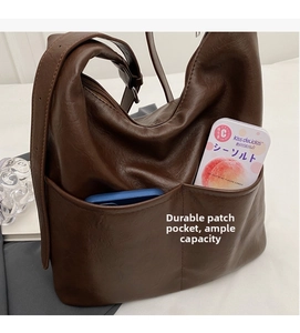 Detail showing deep brown hobo bag pockets for phone storage and durable PU leather