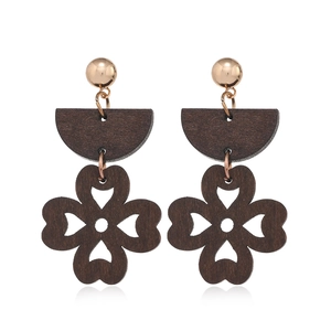Close-up of geometric hollow wood clover earrings with gold studs on white background
