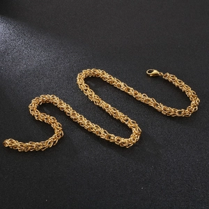 Golden stainless steel crown necklace with thick woven Byzantine chain on black background