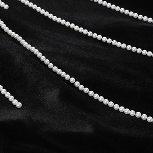 Gros plan de broderies de perles élégantes sur le tissu en velours noir de la robe