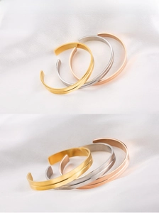 Detail showing brushed stainless steel finish and geometric groove on three-tone C-shape cuffs